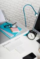 Desk setup with printer, stationery, clock, and lamp for productive work in a modern workspace photo