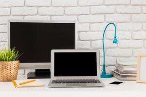 Modern home office setup featuring a laptop, monitor, and organized workspace during daytime photo