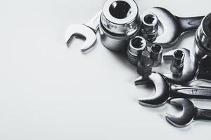 Collection of various metallic tools arranged on a plain surface showcasing their distinct shapes and sizes photo