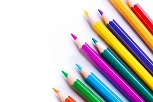 Colorful pencils arranged in a neat line on a white background highlighting creative expression and artistic tools photo