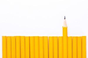 Yellow pencils arranged with one pencil standing out against a white background showcasing creativity and uniqueness in a simple design photo