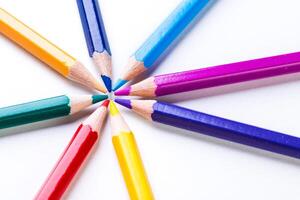 Colorful pencils arranged in a circular pattern on a white background ideal for artistic projects photo