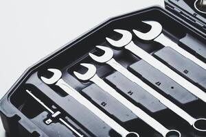Detailed view of a wrench set organized inside a black tool case on a clean surface photo