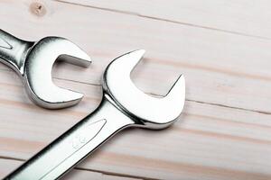 Close-up of shiny wrenches resting on a wooden surface showcasing intricate details of tools designed for manual tasks photo