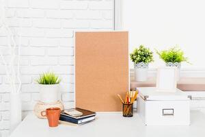Workspace with corkboard, notebooks, and plants creating an organized study environment in a bright room photo