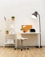 Modern workspace featuring a clean desk, shelving, and warm lighting in a minimalist setting photo