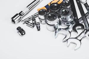 Collection of various hand tools and sockets neatly arranged on a white background for mechanics or DIY projects photo
