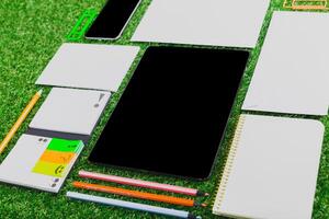 Stationery and digital tools arranged on green grass for creative planning and brainstorming sessions photo
