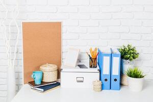Organized workspace featuring storage solutions, stationery, and decorative elements in a bright setting photo