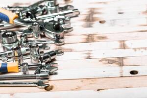 Collection of various hand tools displayed on a rustic wooden surface in a workshop setting, showcasing craftsmanship and utility photo