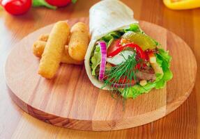 Delicious double cheeseburger on a wooden cutting board with fresh vegetables at a casual dining setting photo
