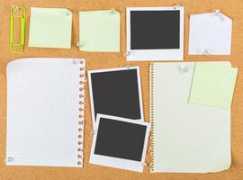 Collection of blank sticky notes and empty photo frames on a corkboard background for organization