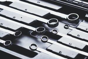 Collection of chrome wrenches organized in a tool case ready for use during a mechanical project in a workshop photo