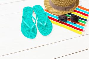 Bright flip flops, stylish hat, and sunglasses on a colorful beach towel ready for a day in the sun photo