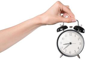 Holding a classic alarm clock during morning routine to ensure punctuality and organization time management skill photo