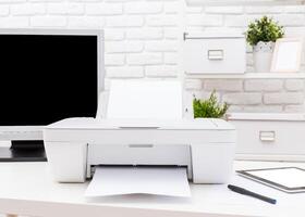 Printer in a modern workspace printing documents on a clean desk with a computer and stationery photo