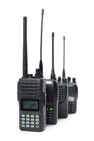 Multiple handheld two-way radios arranged in a row with distinct antennas and displays for communication purposes photo