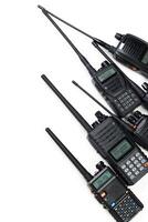 Multiple handheld radios arranged in a row displaying various features and designs for communication photo