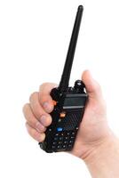 Handheld two-way radio held in a person's hand, showcasing communication technology in an urban environment at daytime photo