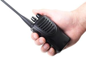 Handheld radio being operated, emphasizing communication in an outdoor setting photo