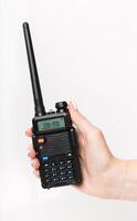 Handheld radio communicator held by a person with a visible display and antenna in a neutral setting photo
