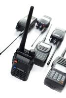 Various handheld radios arranged on a white background showcasing communication devices for diverse applications photo