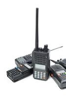 Collection of portable two-way radios arranged on a white background ready for use in communication and signaling photo