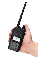 Handheld two-way radio being held in a person's hand for communication outdoors photo