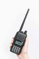 Handheld two-way radio being held with a clear display and antenna during a communication session photo