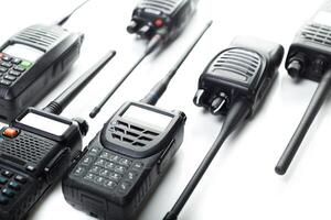 Various models of walkie talkies arranged on a white surface for technology showcase in communication devices photo