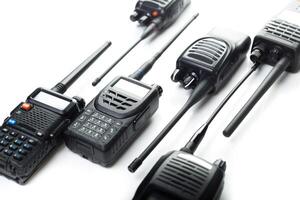 Communication devices arranged on a white surface showcasing various types of walkie-talkies used for professional and recreational purposes photo