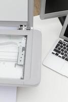 Scanner and laptop on a desk for document processing in a modern workspace photo