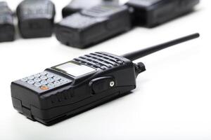 Black two-way radios arranged on a white surface for communication in professional settings and outdoor activities photo