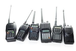 Various models of walkie-talkies lined up for communication purposes in a well-lit environment photo