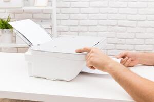 Using a printer to print documents on a clean desk in a bright workspace photo