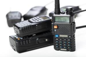 Various models of handheld radios stacked together for communication and emergency use photo