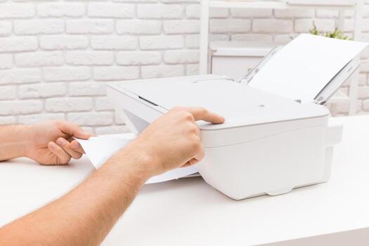 Hands operating a printer in a modern office setting during a productive work session photo