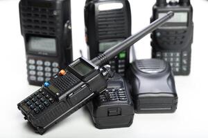 Collection of various handheld communication devices on a plain surface showcasing modern and vintage designs photo