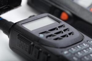 Detailed close-up of a black walkie-talkie showcasing buttons and display in a professional setting photo