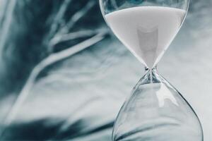 Elegant hourglass with flowing sand displayed in a minimalist setting, symbolizing the passage of time photo