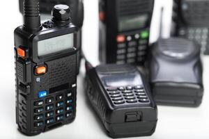 Close-up view of multiple two-way radios on a clean white surface showcasing various models and features photo