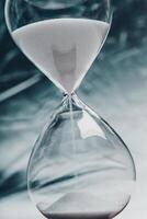 Hourglass steadily measuring time with sand flowing in a minimalist setting photo