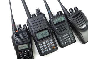 Collection of four handheld two-way radios arranged on a white background showcasing various designs and features photo