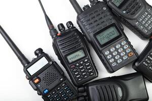 Various handheld radios arranged in a flat layout highlighting communication devices used for versatile operations photo