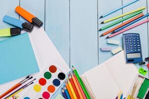Collection of colorful art supplies and tools neatly arranged on a blue wooden surface displaying creativity and organization photo