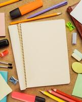 Creative workspace with blank spiral notebook and colorful stationery on wooden desk photo