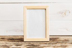 Empty picture frame on rustic wooden surface with soft natural background photo