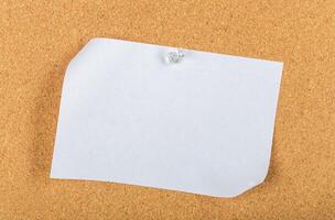 Blank sticky note pinned to a corkboard in an office setting during daylight hours photo