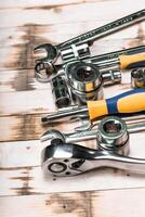 Collection of assorted metal hand tools arranged on wooden surface for home repair tasks and DIY projects photo