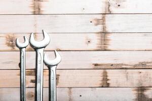 Metal wrenches arranged on a wooden surface showcasing craftsmanship and tools used in mechanical work photo